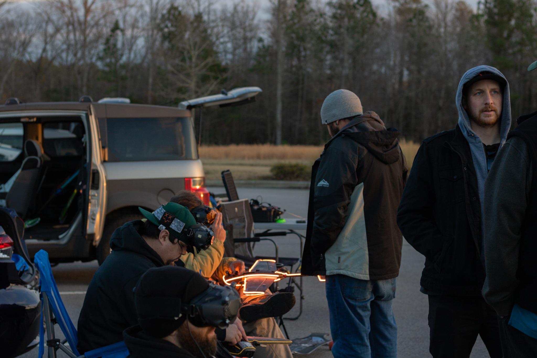 A group of FPV pilots preparing equipment beside their vehicles